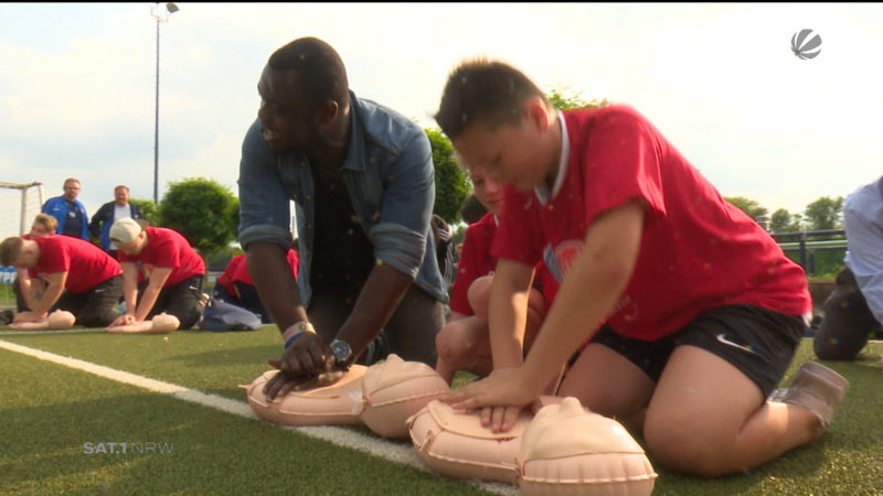 Gerald Asamoah übt mit Kindern Wiederbelebungsmaßnahmen (Foto: SAT.1 NRW)