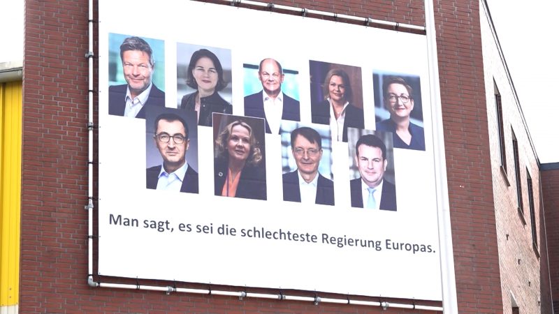 Olaf Scholz mit Protestplakat empfangen (Foto: SAT.1 NRW)